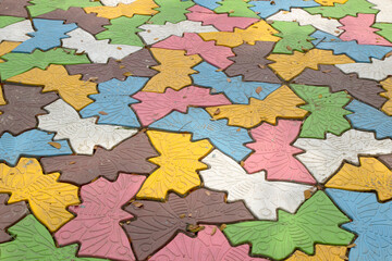 The multicolored walkway block ground with leaf litter and dirty.