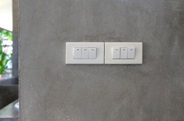 Six light switch on grey concrete wall.