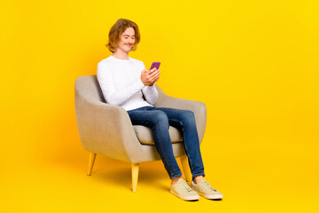 Fototapeta na wymiar Photo of sweet attractive guy wear white shirt typing modern gadget isolated yellow color background