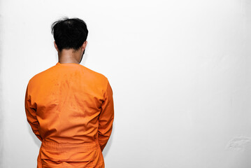 Prisoner in orange robe concept,Portrait of asian handsome man in Prison uniforms,Bandit has a lot of muscle,