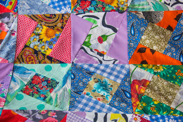 Fototapeta na wymiar Background of Part of patchwork quilt with flower print. Handmade color blanket in style patchwork.
