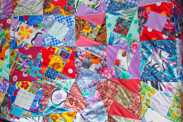 Fototapeta na wymiar Background of Part of patchwork quilt with flower print. Handmade color blanket in style patchwork.