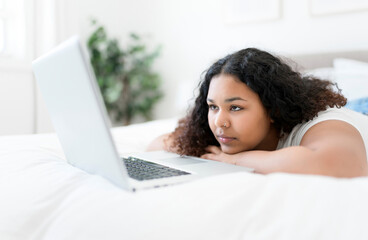 Fototapeta na wymiar girl using laptop in bed during morning time at home
