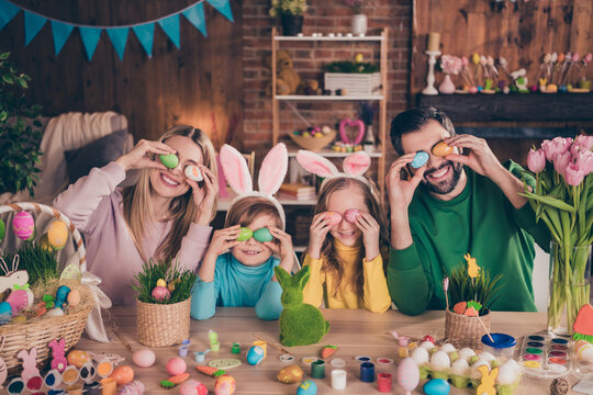 Photo of cheerful good mood laughing family cover close eyes with easter eggs prepare celebrate spring holiday