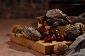 Dried fruits and walnuts on a brown board. Dried persimmon and dried dates