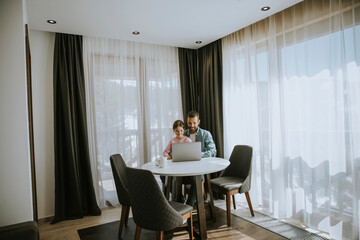 Father and daughter using laptop computer together