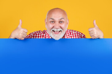 happy senior man with copy space on blank banner. advertisement. thumb up