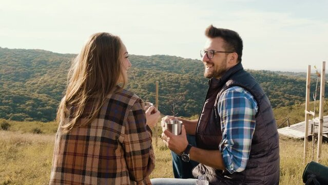 Couple resting after hiking sitting and drinking tea.