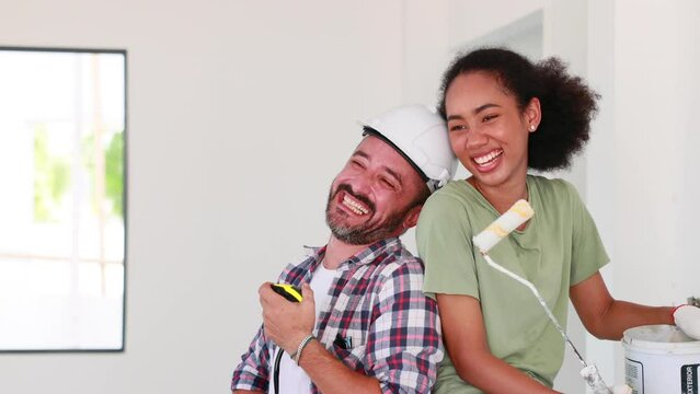 Portrait Cheerful couple young man and black woman smiling during renovation in new apartment