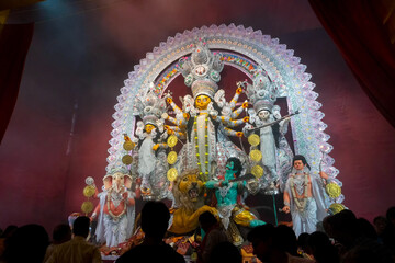 Kolkata, India - October 18, 2018 : Goddess Durga idol being worshipped inside decorated Durga Puja pandal, shot at colored light at night. It is the biggest festival of Hinduism.