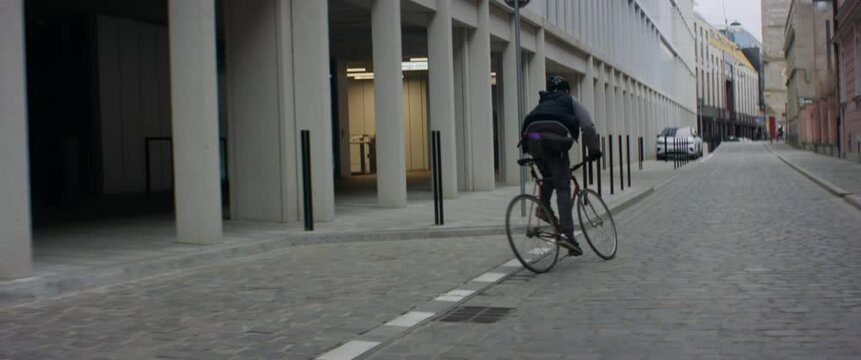 TRACKING Young Caucasian male commuting on his vintage fixed gear bicycle through the city