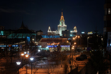 Fototapeta na wymiar Moscow, Russia - 18 February, 2022: Main building of Moscow State University at winter night in Moscow, Russia, view through residential areas