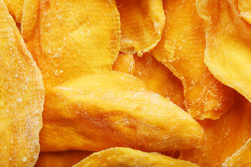 Pieces of sweet dried mango close-up as a background in full screen