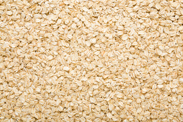 Dry rolled oat background. Closeup. Healthy food. Top down view.