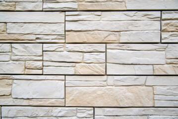 Background of beige bricks. Wall of beige bricks. The texture of the wall. Texture of beige decorative tiles in form of brick.