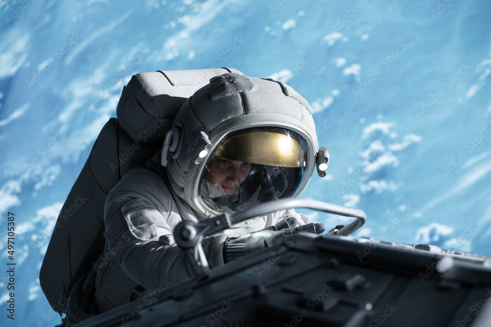 Canvas Prints female astronaut performing spacewalk, working on a outer part of a space craft