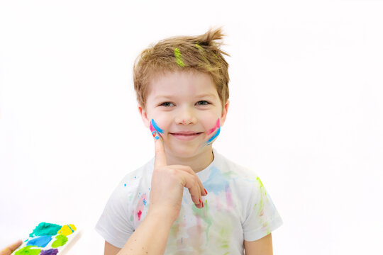 Portrait of a boy whose face is painted with paints. White background . High quality photo