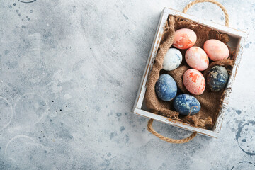 Easter eggs. Dyed Easter eggs with marble stone effect ref and blue color in rustic style on light grey stone background. Easter background. Top view.