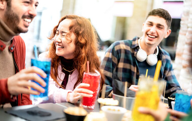Young people on genuine laugh moment at fancy pub restaurant outside - Life style concept with trendy friends sharing happy hour time together at sidewalk cafe - Vivid filter with focus on asian woman