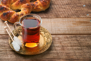 Turkish black tea. Glass cup of turkish black tea and crispy Turkish traditional bagel on old rustick background. Breakfast pastry concept. Traditional turkish brewed hot drink.