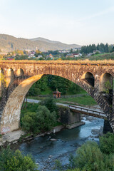 Fototapeta na wymiar Vorokhta, Ukraine – September 24, 2021: A big, old, ancient aqueduct bridge in the mountains