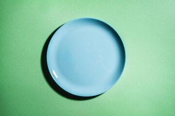 Blue empty plate on green background