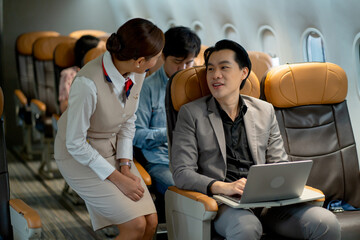 Business man use laptop during take plane go to work in other place and he also talk with air...