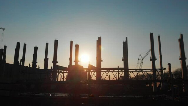 Construction site. New building architecture. Industrial heavy machinery production area of ecological modern factory plant development. Sunset. Landscape.