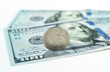 Russian rouble coin on banknotes of dollars isolated. Concept of currency exchange. Decline of the...
