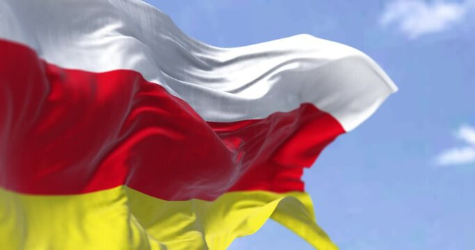 Detail of the national flag of South Ossetia waving in the wind on a clear day.