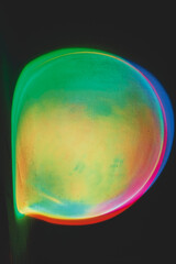 Abstract image of colorful shapes of light against black background