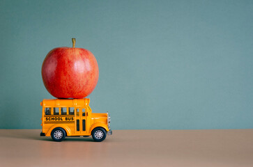Teacher Appreciation Week school background. Red apple on orange toy school bus and place for text....