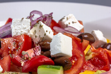Greek salad of tomatoes, cucumbers, vegetables with olives and feta cheese.