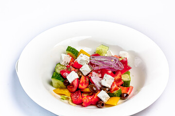 Greek salad of tomatoes, cucumbers, vegetables with olives and feta cheese.
