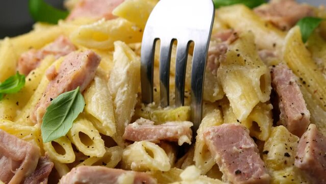 Eating Hawaiian pasta with ham, pineapple and creamy cheese