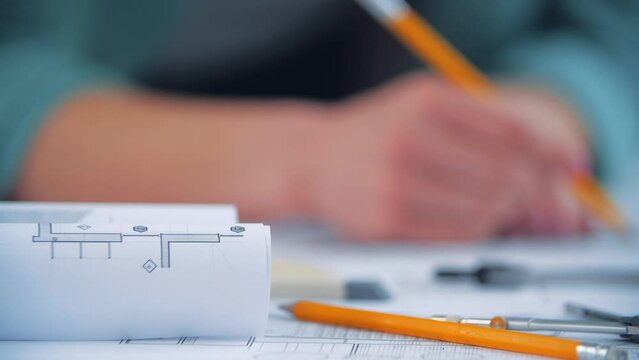 4k video of blurred female hand with yellow pencil working.