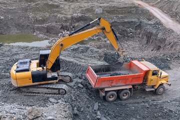 the process of loading soil with a bucket excavator at a construction site