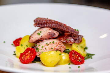Traditional Spanish octopus salad with potatoes, drizzled with olive oil