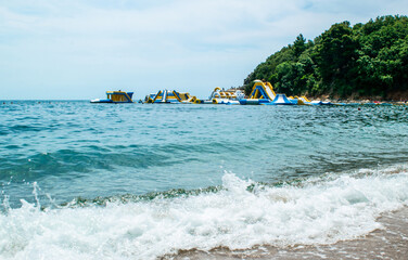 People on Inflatable entertainment water attractions and slides on sea. Morgen beach, Montenegro.