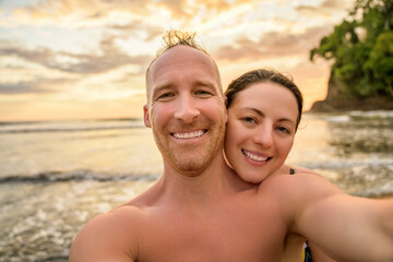 Obraz premium Loving cheerful happy couple taking selfie on the side of the beach