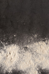 flour on a black table background