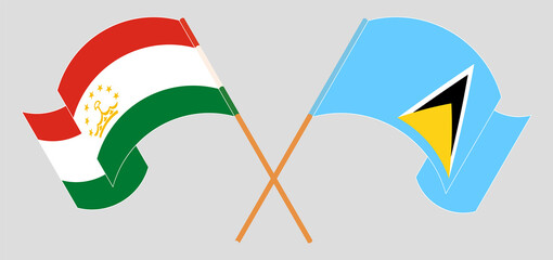Crossed and waving flags of Tajikistan and Saint Lucia