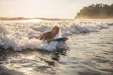 woman with Boogie board on the beach at the sunset