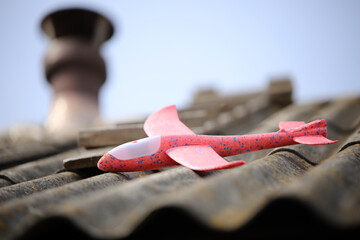 plastic pink plane toy on the roof, photo for text