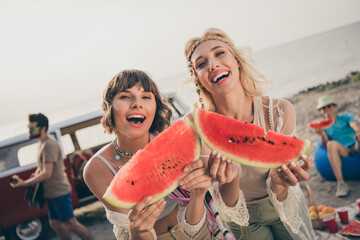 Photo of excited glad funny girls 60s style fest enjoy slice watermelon wear boho outfit nature seaside beach outside