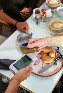 Close-up of man paying with credit card in restaurant