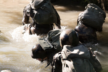 Militaires qui traversent une rivière