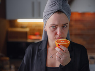 Sick woman trying to sense smell of fresh orange, has symptoms of Covid-19, corona virus infection....