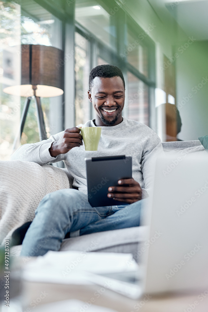 Poster movie time the mobile way. shot of a young man using a digital tablet and having coffee on the sofa 
