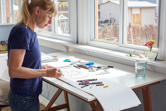 Mature woman drawing at home